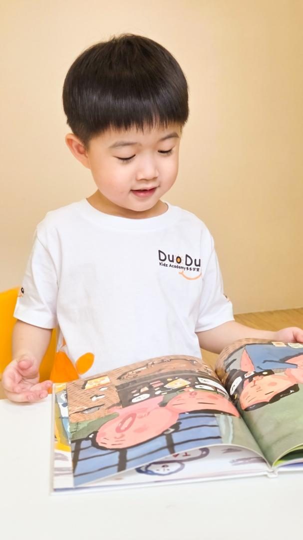 Budak lelaki membaca buku bergambar sendiri