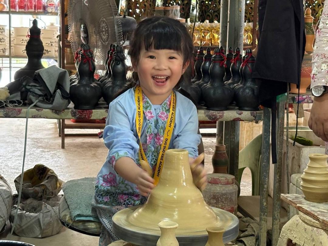 DuoDuo student laughing at a pottery wheel on a learning trip