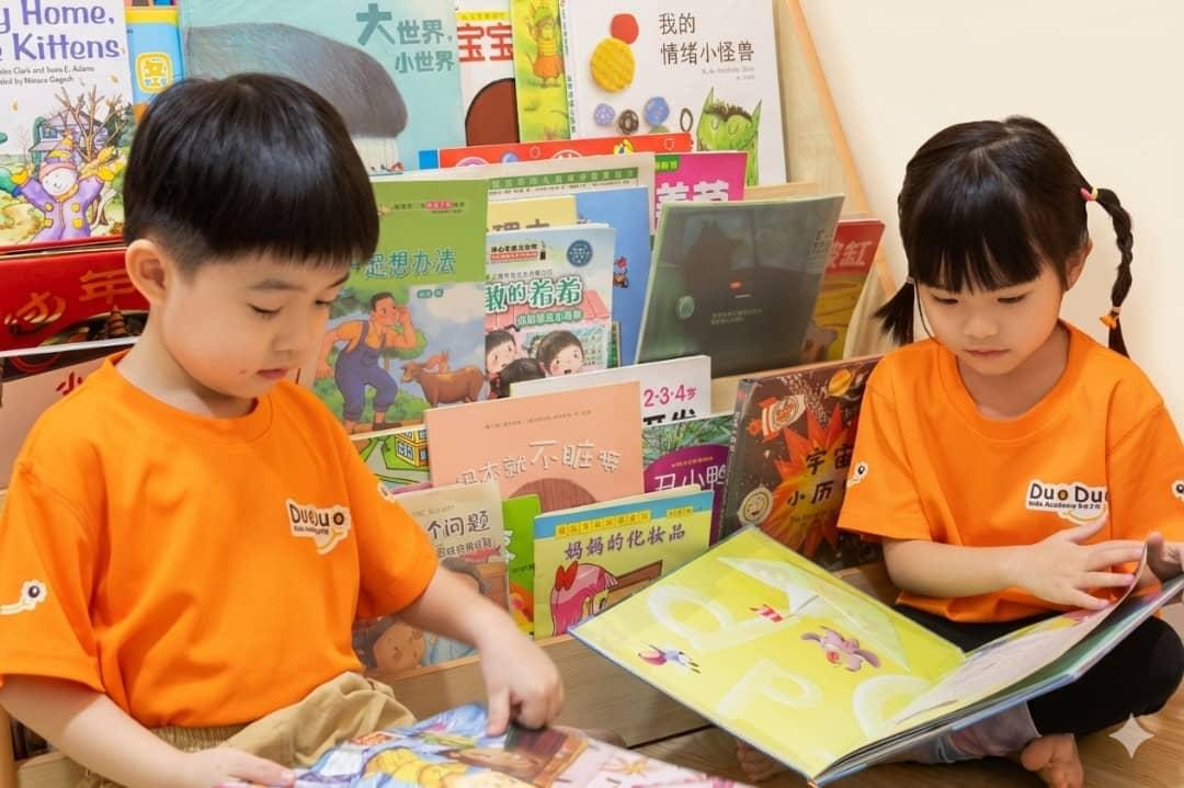 DuoDuo children reading picture books in the reading corner